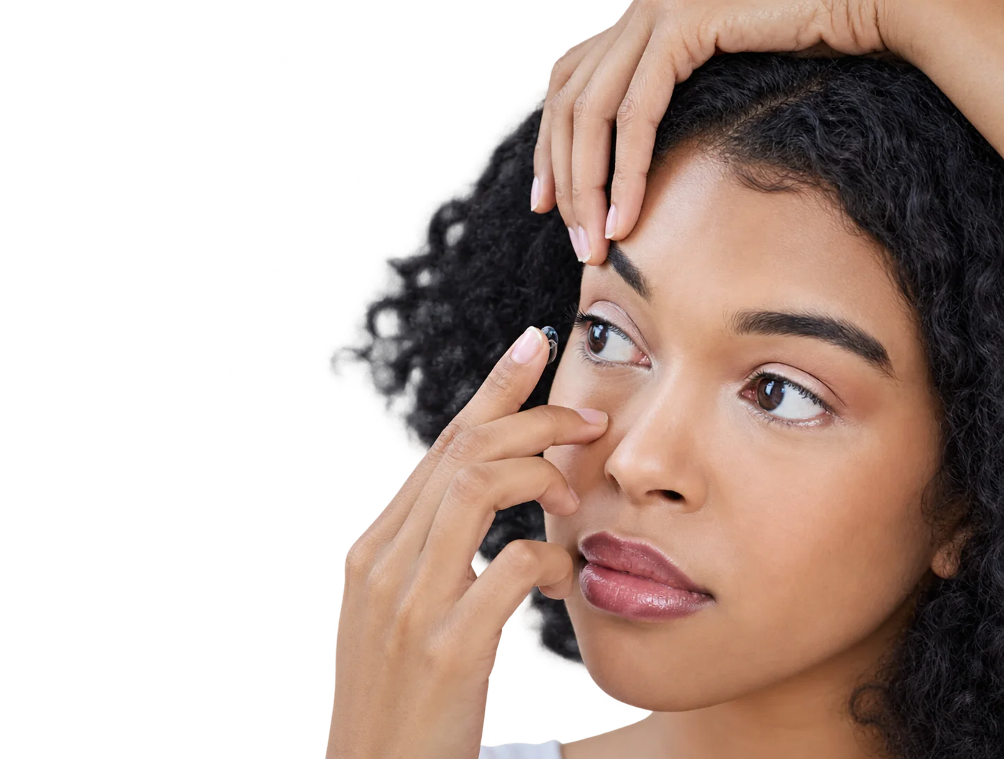 Jeune femme appliquant une lentille de contact devant un miroir